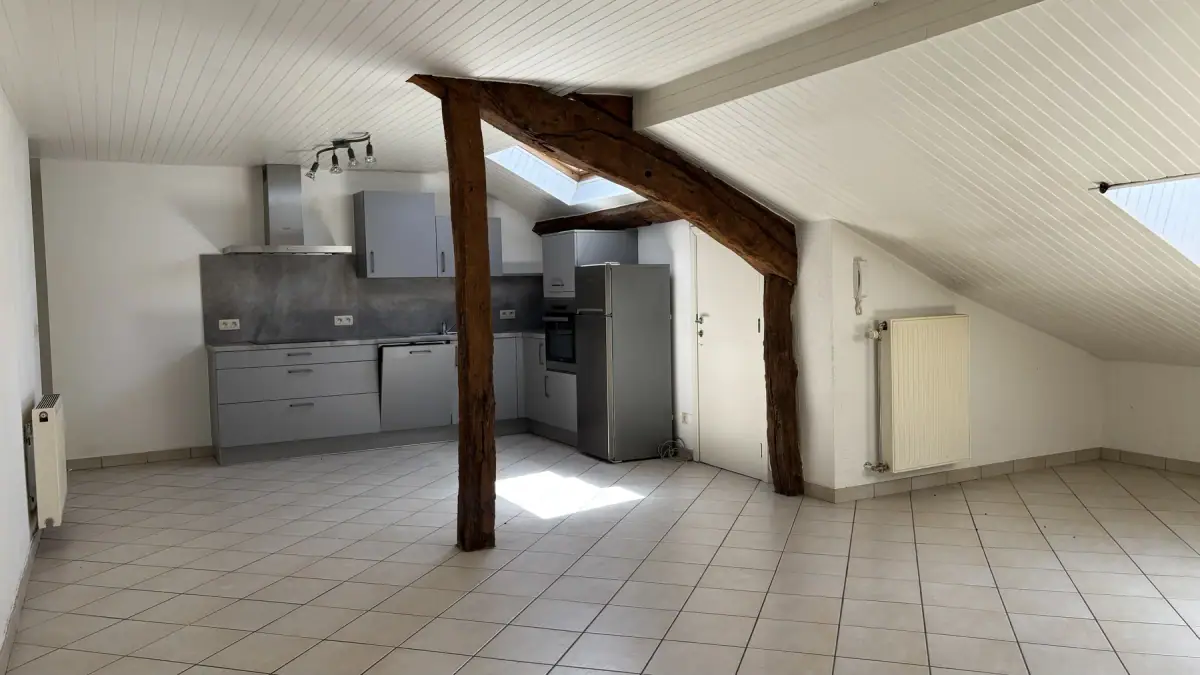 La pièce de vie sous les poutres de l’appartement n° 15