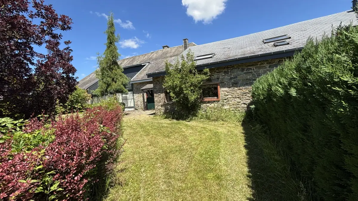 La façade arrière en pierre et le jardin de la maison de Pierre