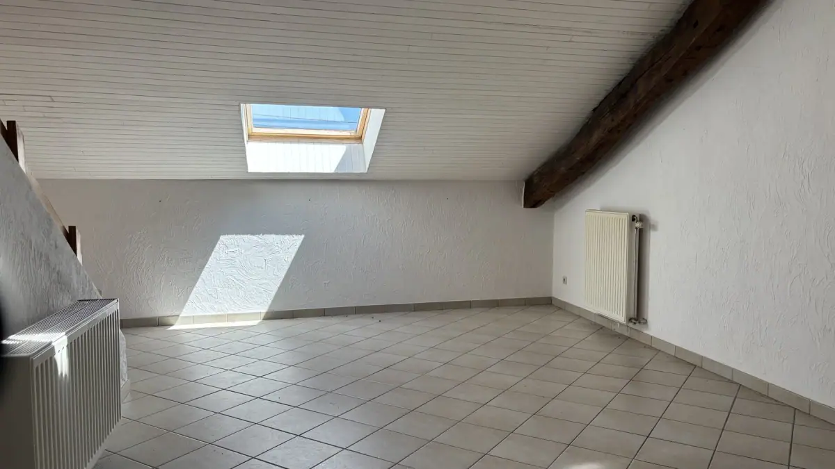 La pièce de vie actuelle du studio sous le Velux et la poutre ancienne